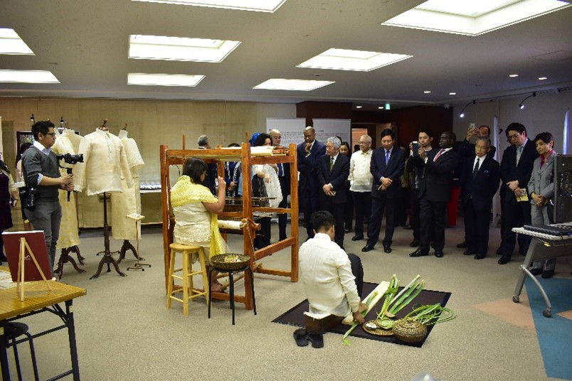 Photograph of visitors watching the weaving and scraping demonstration