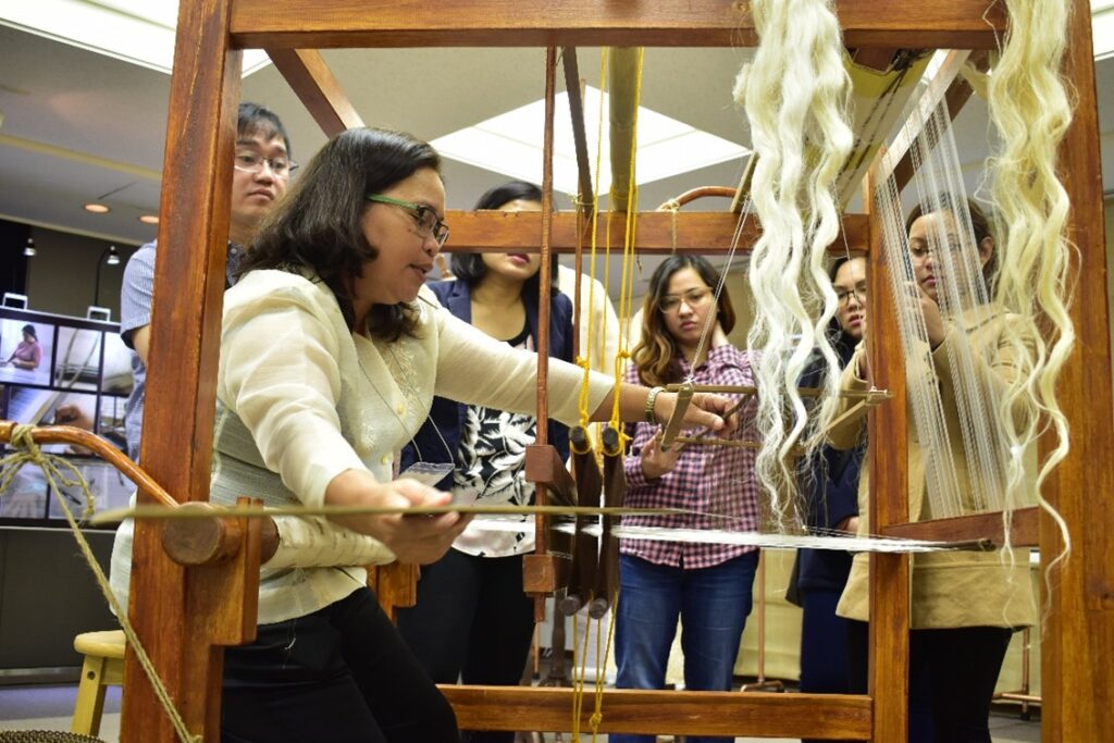 Photograph of a woman weaving