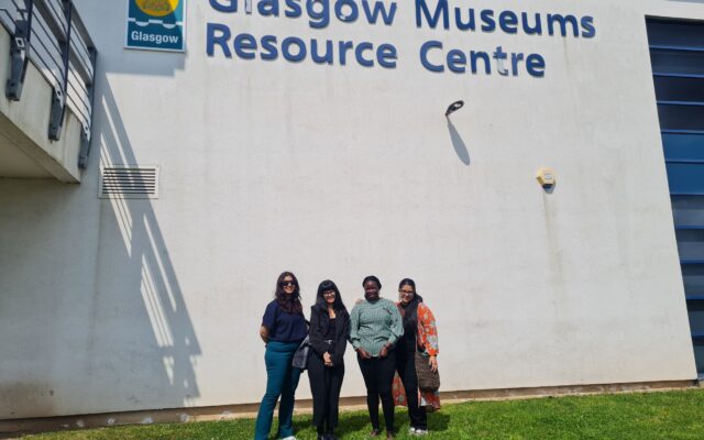 Four people photographed outside Glasgow Museums Resource Centre