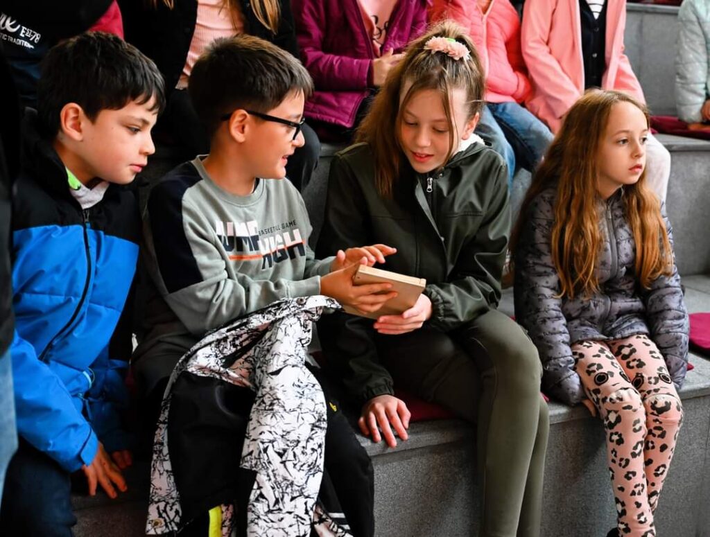 Photograph of children looking at a wooden tablet.