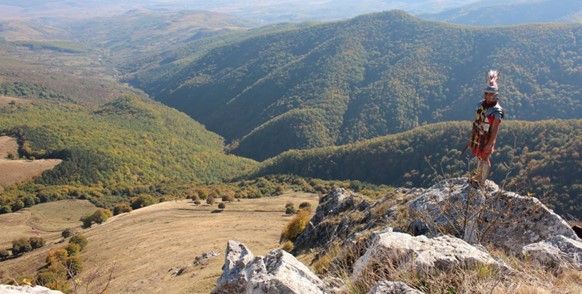 Image of a man stood overlooking rolling hills.