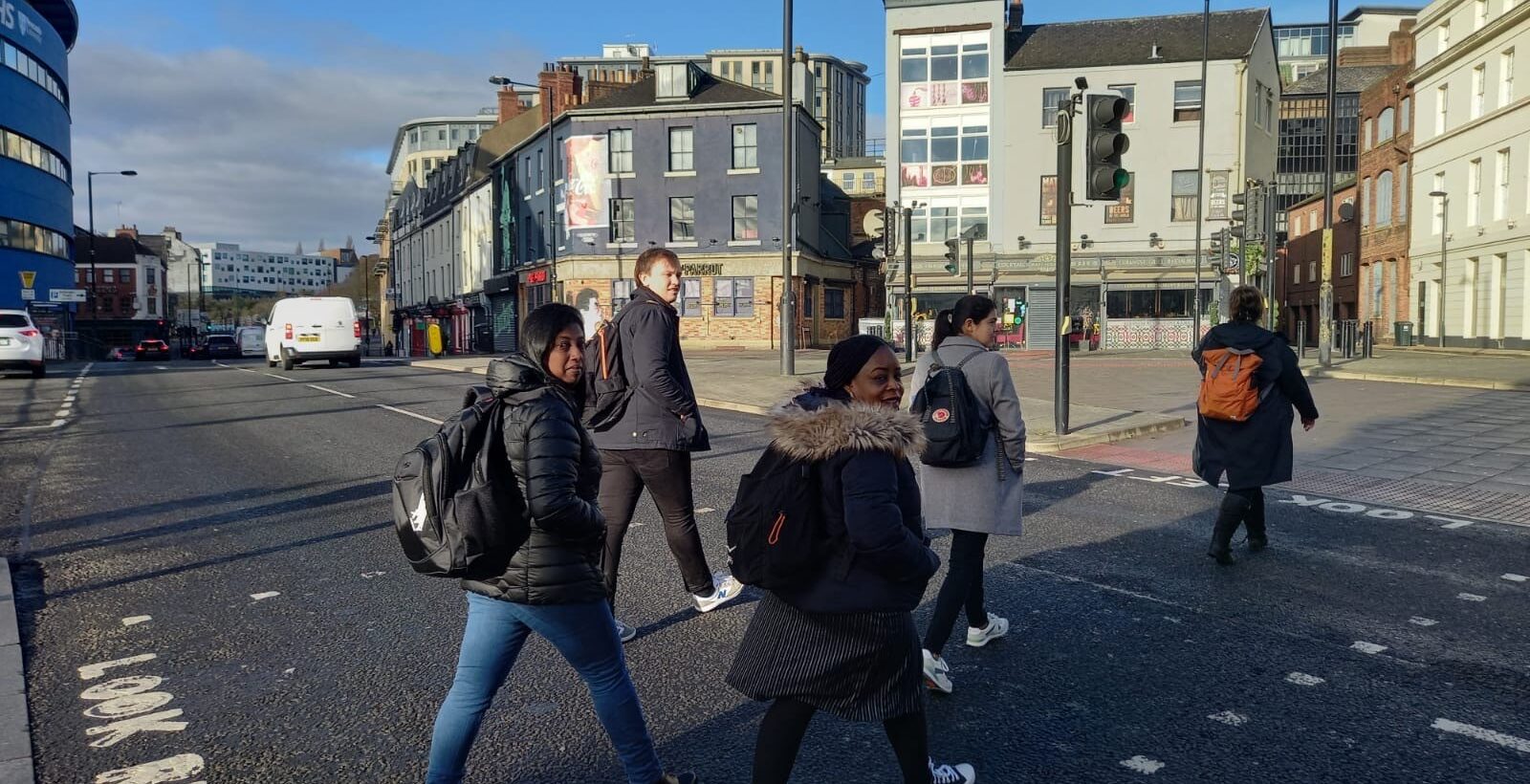 Photograph of five people crossing a road