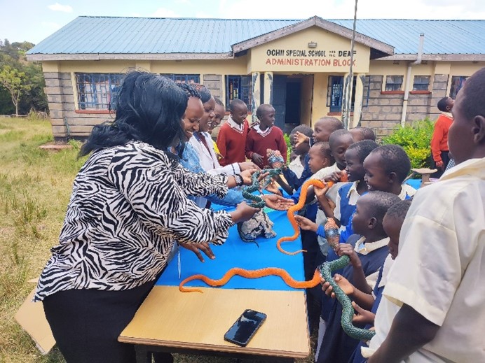 Children touching model snakes.