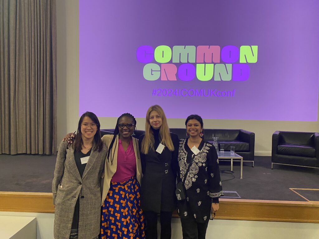 Photograph of four women stood in front of a projection that says 'common ground'