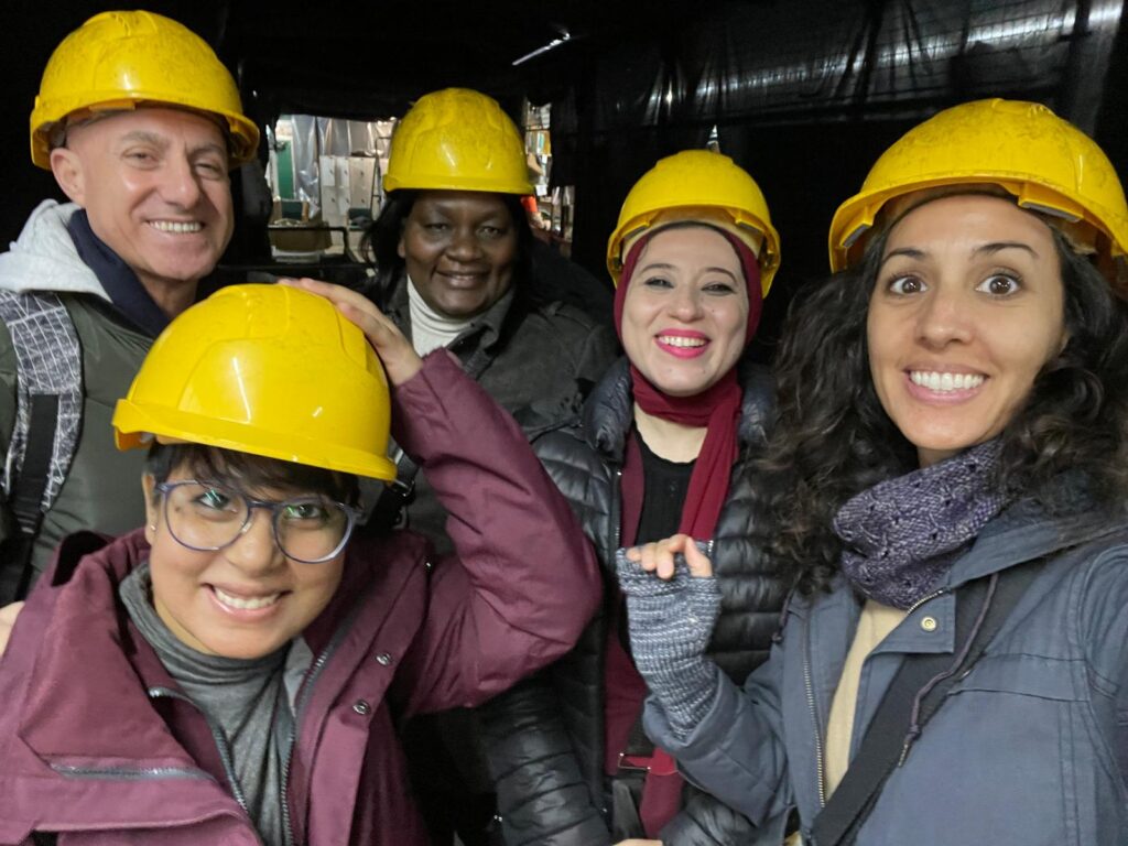 Photograph of five people wearing yellow hard hats.