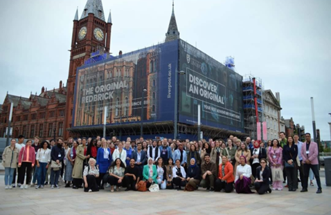 Group photo of people stood outside Liverpool University