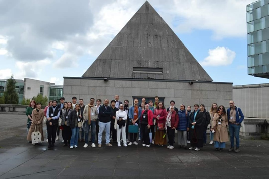 Group photo in front of a concrete spire