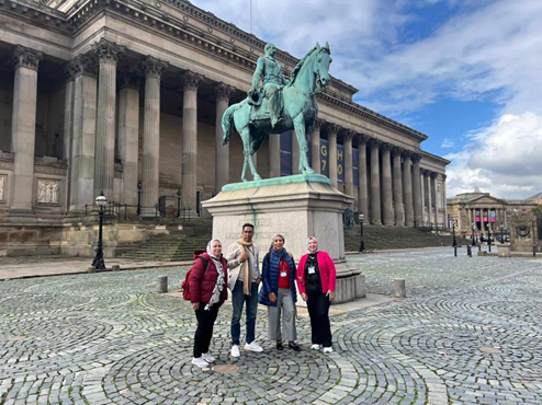 Group photo in front of a statue